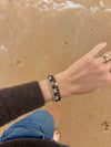 Aquamarine and Bronzite Beaded Bracelet stacked on the wrist above the sand at the beach