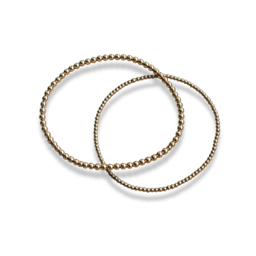 Interlocking 14k gold-filled beaded stacking bracelets shown together on a light background