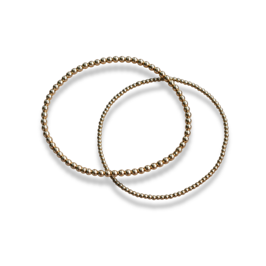 Interlocking 14k gold-filled beaded stacking bracelets shown together on a light background
