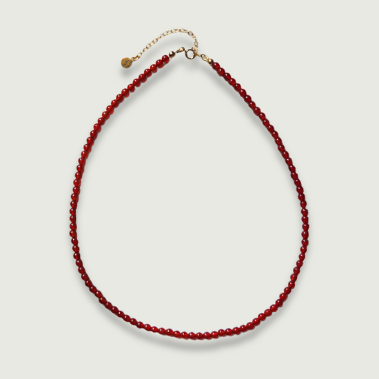 Red carnelian necklace on a light gray background