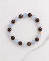 Aquamarine and Bronzite Beaded Bracelet in gold, laid flat on white marble