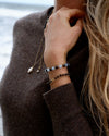 Aquamarine and Bronzite Beaded Bracelet worn stacked with bronzite and gold bracelets by the ocean